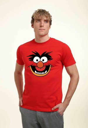 Red cotton t-shirt featuring a large, cartoonish black-haired character face, with white eyes, an orange nose, and a wide grin.
