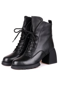 Bottes basses en cuir noir avec talons épais, lacets à l'avant et languette à l'arrière, conçues pour le style et la durabilité.