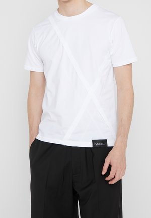 Witte t-shirt met korte mouwen en een diagonaal, textuurontwerp. Voorzien van een zwart label aan de zoom en een standaard ronde hals.