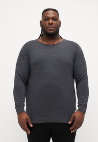 Gray sweater made of textured knit fabric, featuring a wide neckline and long sleeves. Ribbed cuffs and hem with subtle flecks.