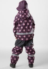 Paarse regenpak met grote roze sterren, voorzien van een capuchon en elastische manchetten, gecombineerd met grijze accenten en reflecterende strips, geschikt voor buitengebruik.