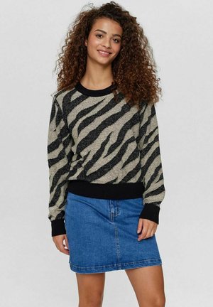Kaki och svart randig tröja med metalltrådar, ribbad halsringning och muddar, i kombination med en blå denimkjol med framfickor.