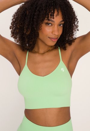 Mint green ribbed crop top with thin straps, featuring a logo on the left side. The fabric has a smooth texture and a fitted design.