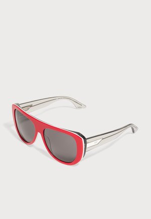 Occhiali da sole con montatura frontale rossa e aste grigie traslucide, con lenti scure su uno sfondo chiaro uniforme.