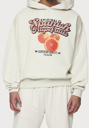 Sudadera con capucha color crema con un gráfico de pomelos naranjas y texto. Cuenta con una capucha con cordón ajustable y puños y dobladillo acanalados. Textura suave.