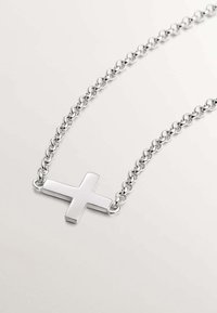 Collar de cadena de plata con un colgante de cruz pulido. La cruz está centrada, con un acabado suave y un diseño de cadena entrelazada.