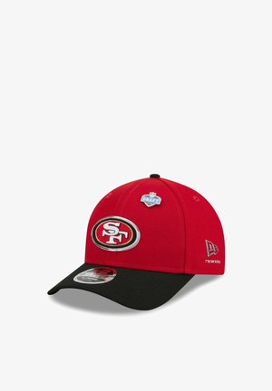 Casquette rouge et noire des San Francisco 49ers avec logo de l'équipe à l'avant et écusson NFL Draft 2023 sur le dessus.