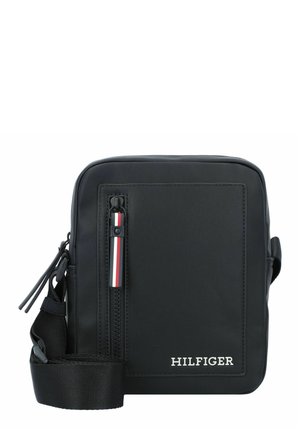 Borsa a tracolla nera in nylon con superficie testurizzata, zip superiore, accento rosso e bianco sul tirante della zip, tracolla regolabile e dettaglio logo frontale.