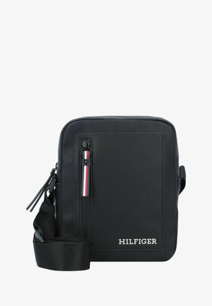Borsa a tracolla nera in nylon con superficie testurizzata, zip superiore, accento rosso e bianco sul tirante della zip, tracolla regolabile e dettaglio logo frontale.