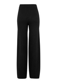 Mustat korkea vyötäröinen leveälahkeinen neulehousut kuminauhavyötäröllä, näkyvissä takaa valkoista taustaa vasten.