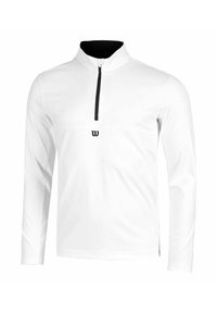 Chemise blanche à manches longues avec col noir à demi-fermeture éclair, comportant un petit logo noir sur le devant et un tissu lisse et léger.