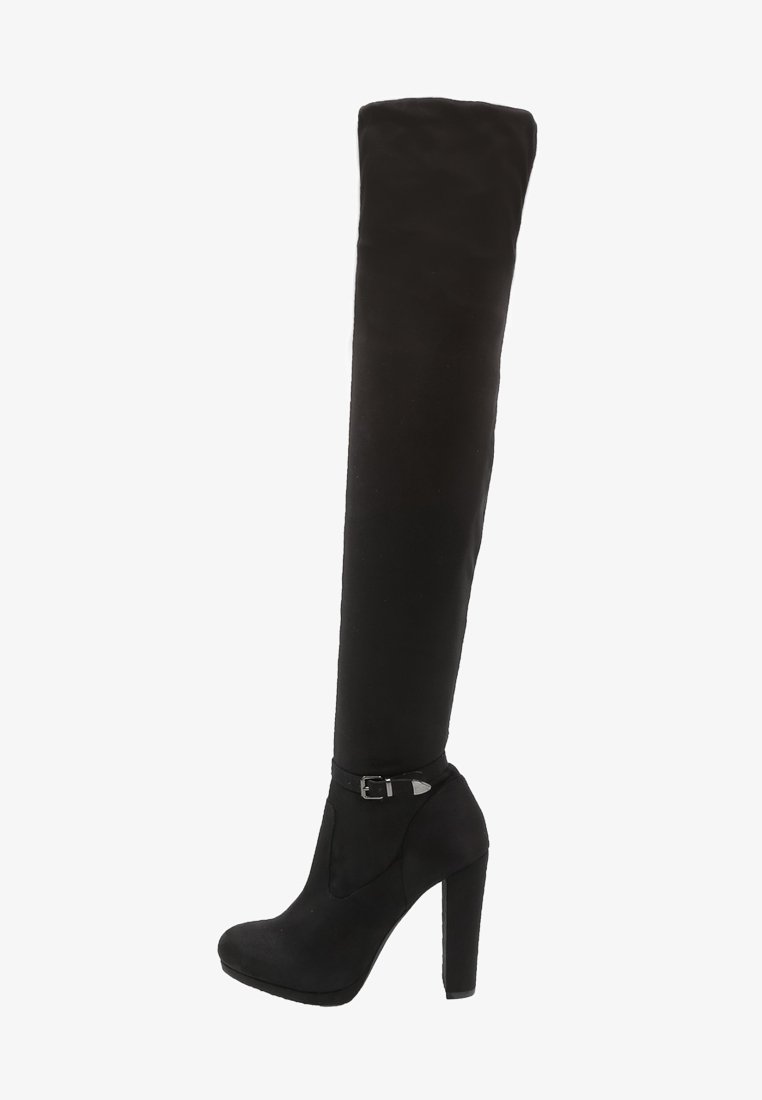 Botte noire à talon haut montant jusqu'à la cuisse, avec un bout arrondi, une semelle plateforme et une petite sangle décorative avec boucle au-dessus de la cheville.