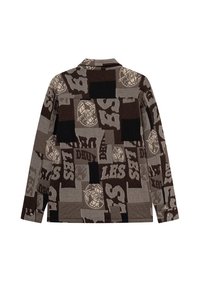 Brązowa koszula w wzory, zawierająca mix kwadratów w ciemnym brązie, jasnym brązie i czerni, z graficznymi akcentami i oversize'owym krojem.