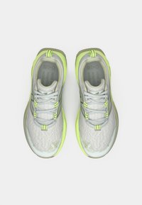 Hellgraue Sportschuhe mit grünen Akzenten, Mesh-Obermaterial und strukturierten Oberflächen. Ausgestattet mit Schnürsenkeln und verstärkter Zehenkappe für Langlebigkeit.