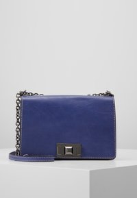 Borsa a tracolla in pelle blu con tracolla a catena, forma rettangolare, hardware argentato e dettagli di cucitura a contrasto sui bordi.