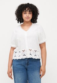 White short-sleeve blouse with a V-neck, button closure, and a decorative lace hem. Material appears lightweight and textured.