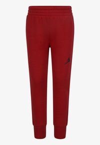 Pantalons de survêtement rouges en tissu doux avec une taille élastique et des poignets. Présente un logo Jumpman noir sur la cuisse gauche.
