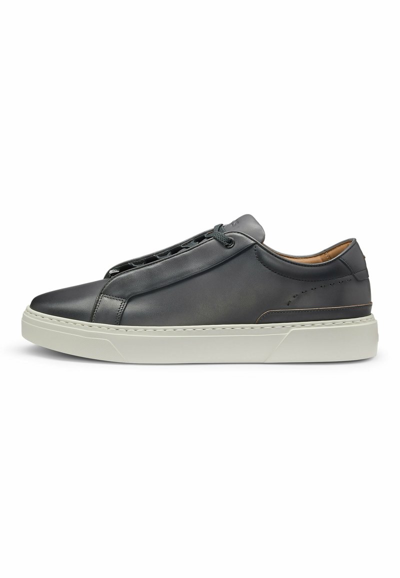 Black leather sneaker featuring a rounded toe, minimalistic design, and grey rubber sole. Includes lace closure and subtle stitching details.