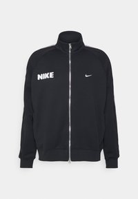 Chaqueta de chándal negra de Nike con cierre de cremallera y cuello alto, que presenta un logo blanco en el pecho y texturas contrastantes a lo largo de las mangas.