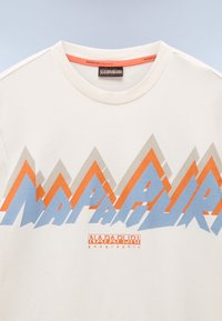 Krémové bavlněné tričko s vícolorským horským grafickým motivem v modré, oranžové a šedé barvě. Obsahuje text "NAPAPIJRI geographical" v červené barvě.