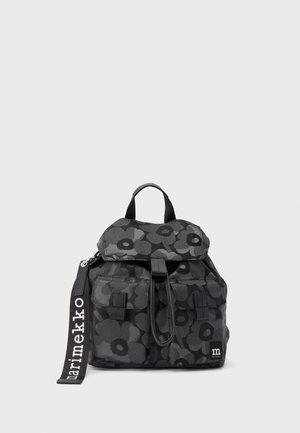 Sac à dos noir et gris foncé à motif floral, avec deux poches à l'avant, une poignée supérieure et une sangle étiquetée "marimekko" sur un fond uni.