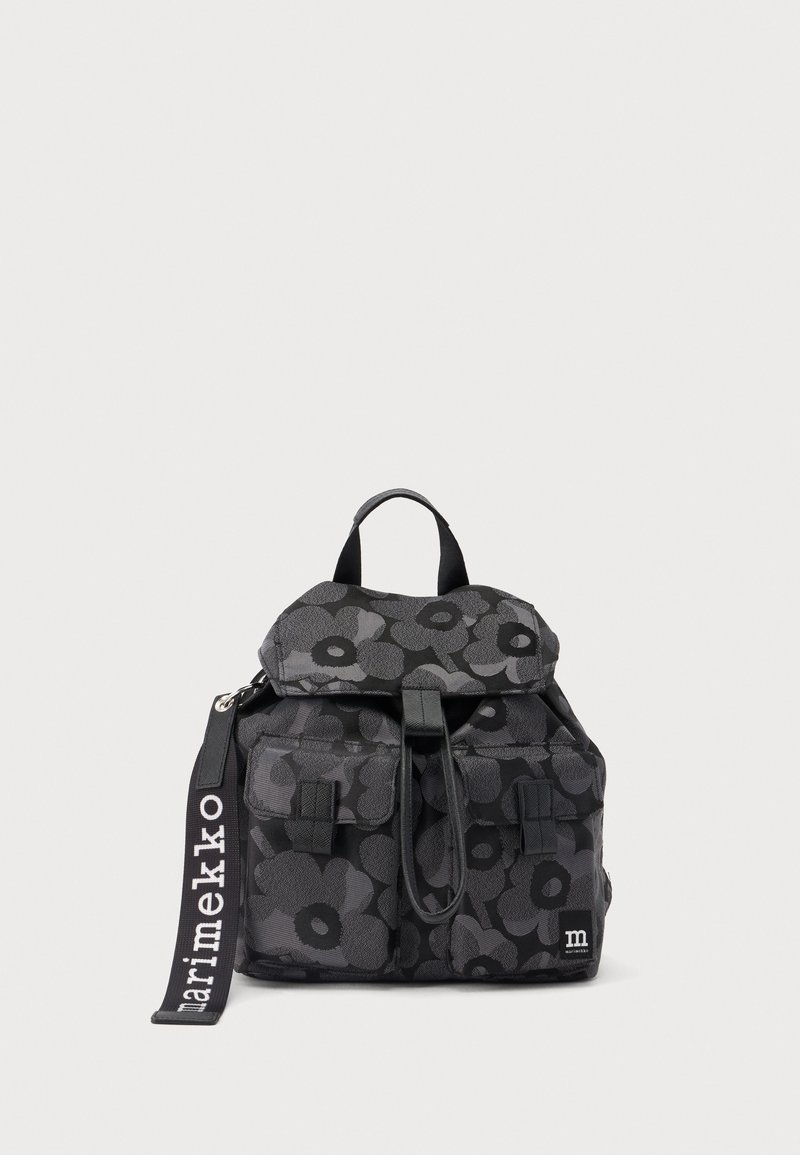 Sac à dos noir et gris foncé à motif floral, avec deux poches à l'avant, une poignée supérieure et une sangle étiquetée "marimekko" sur un fond uni.