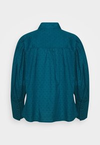 Bluse med lange ærmer i blågrøn farve med lille prikket tekstur, puffede ærmer, knappede manchetter og en let samlet bagpå.