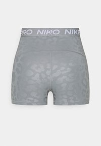 Pantalones cortos grises con un sutil estampado de leopardo, fabricados con tejido elástico. Cuentan con una cinturilla blanca con el logo de Nike y costuras planas para mayor comodidad.