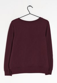 Sudadera de manga larga borgoña oscura colgada en un perchero de metal negro sobre un fondo blanco, vista desde la parte posterior.