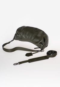 Borsa in pelle verde oliva con una finitura morbida e texture. Include una tracolla regolabile e una targhetta coordinata, caratterizzata da un design rotondo e arricciato.
