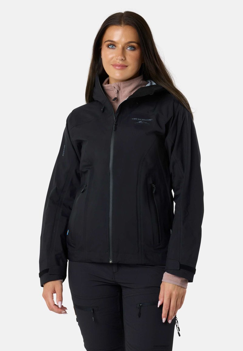 Sort vandtæt jakke med lynlås foran, justerbare manchetter og to lynlåslommer. Har et logo på venstre bryst og en tætsiddende design.