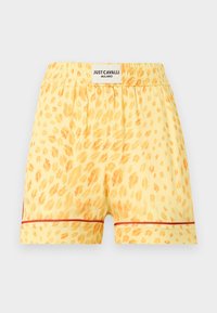 Shorts jaunes à taches léopard orange, taille élastique, bordure rouge près de l'ourlet, et une étiquette blanche portant l'inscription "Just Cavalli Milano" sur la ceinture arrière.