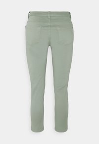 Mintunvihreät, joustavat farkut, joissa on kapea istuvuus. Niissä on kaksi takataskua, saumaton muotoilu ja siisti lahkeen reuna nilkassa.