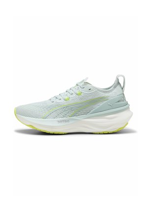 Chaussure de sport bleu clair avec tige en mesh, talon renforcé et semelle épaisse blanche avec accents verts. Dispose de lacets plats et d'un logo.
