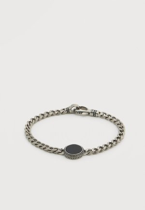 Silver chain bracelet with an oval black stone centerpiece. Features textured metal accents and a secure clasp.