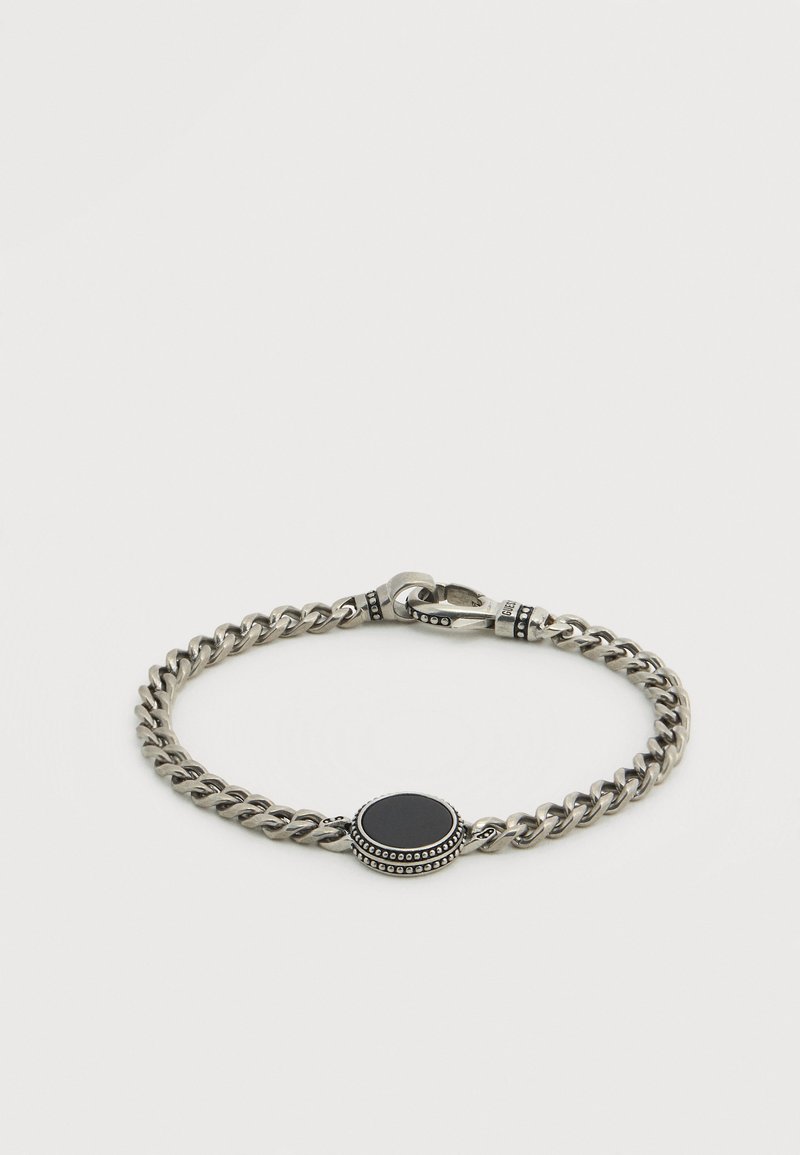 Ασημένιο βραχιόλι με αλυσίδα και οβάλ μαύρο πέτρινο κεντρικό στοιχείο. Διαθέτει μεταλλικές λεπτομέρειες με υφή και ασφαλές κούμπωμα.