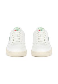 Baltos sportinės bateliai su odiniu viršumi, apvalia nosimi, perforuotomis detalėmis ir žalia Reebok logotipu. Storas kreminės spalvos guminis padas, užtikrinantis sukibimą.