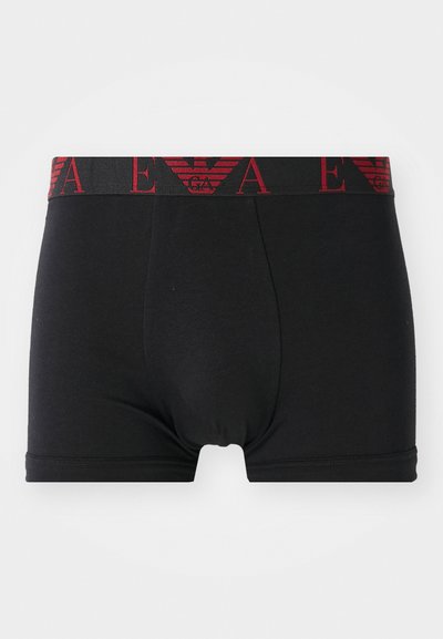Boxeri negri dintr-o țesătură moale, cu o talie lată ce are textul logo-ului roșu și un emblema cu un vultur. Textură netedă.
