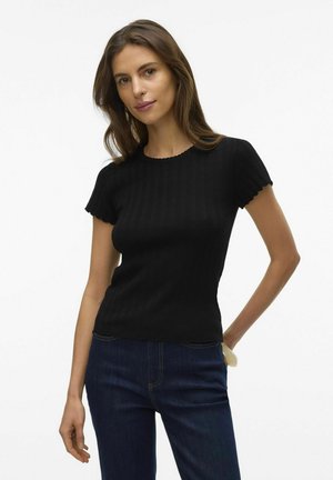 Haut en tricot noir à côtes avec des manches courtes, un décolleté festonné et une silhouette ajustée, associé à un jean en denim bleu foncé.