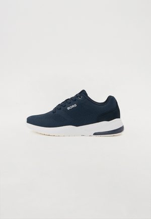 Scarpa sportiva blu navy con tomaia in rete testurizzata, suola bianca e branding discreto. Presenta una punta arrotondata e lacci piatti.