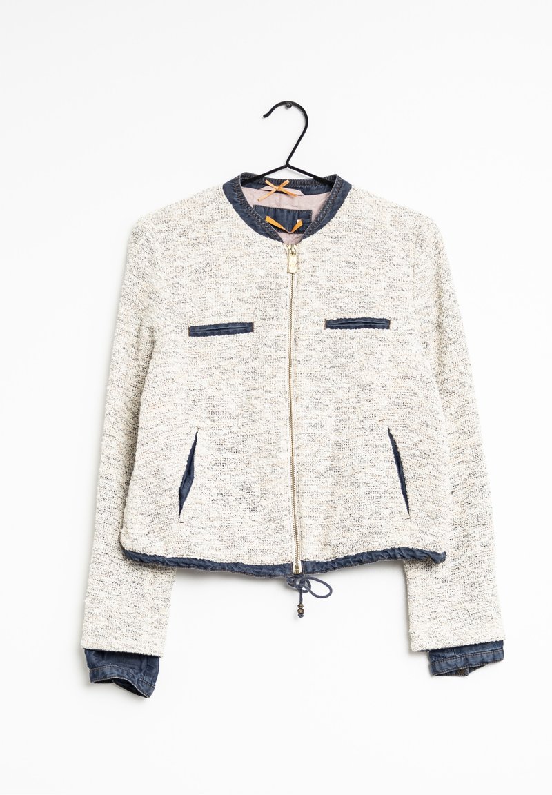 Bomberka z mieszanki wełny, w szarym melanżu z denimu. Posiada zamek błyskawiczny z przodu, dwie kieszenie na piersi i regulowany dół.