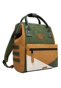 Sac à dos en velours côtelé avec des textures vertes et brunes, une poche zippée à l'avant, des accents en cuir et un motif géométrique en blanc et vert.