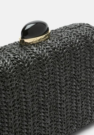 Črna pletena torbica z teksturirano površino, na zgornji strani pa ima zlato zaponko, okrašeno z gladkim črnim kamnom.