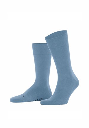 Paar schlichte blaue Socken in Knöchellänge, aufrecht stehend vor weißem Hintergrund.