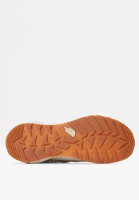 Suela de goma con un patrón texturizado en zigzag; color naranja; logotipo de The North Face grabado cerca del centro. Diseño duradero y robusto.