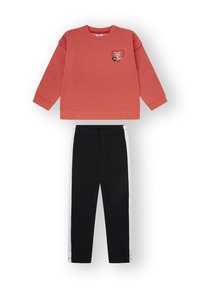 Sudadera coral de manga larga con gráfico de corazón y texto "Te doy mi corazón", combinada con pantalones negros con franjas blancas laterales.