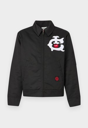 Črna jakna ima sprednji zadrgo, ovratnik in dva stranska žepa. Opazni detajli vključujejo belo grafiko in rdeč emblem na robu.