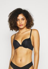 Black padded bra with smooth fabric, adjustable straps, and a plunging neckline. Accompanied by matching black panties.