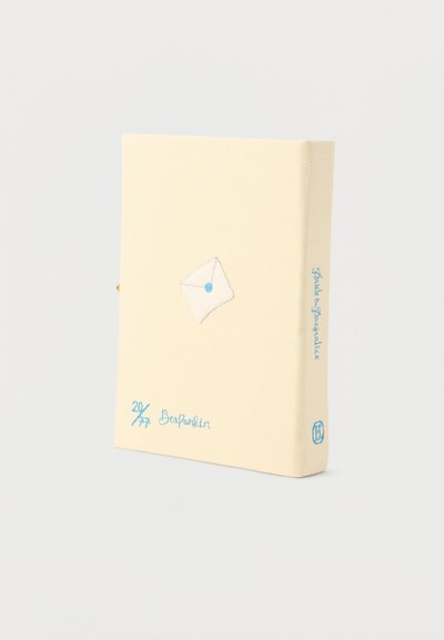 Βιβλίο καλυμμένο με μπεζ ύφασμα, με μπλε χειρόγραφα και ένα κεντημένο λευκό φάκελο με μπλε σφραγίδα στο εξώφυλλο.