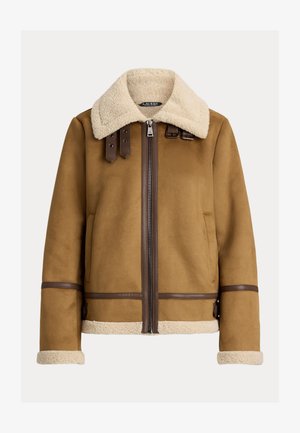 Brun shearling jakke med en blød cremefarvet krave, lynlåsfortving, læderdetaljer og to forlommer med brune detaljer på ærmerne.